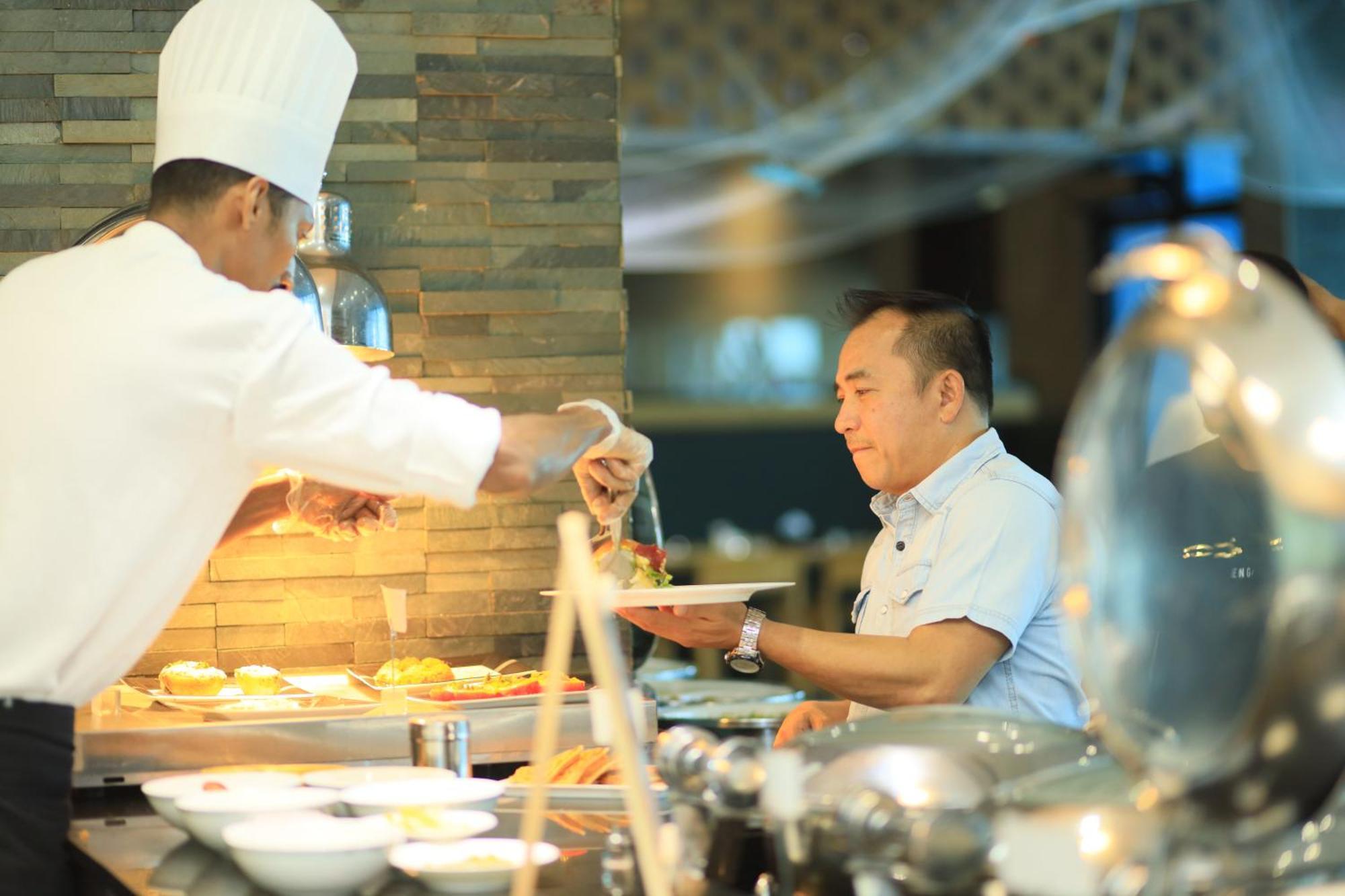Ramee Grand Hotel And Spa Μανάμα Εξωτερικό φωτογραφία A chef serving food at a buffet